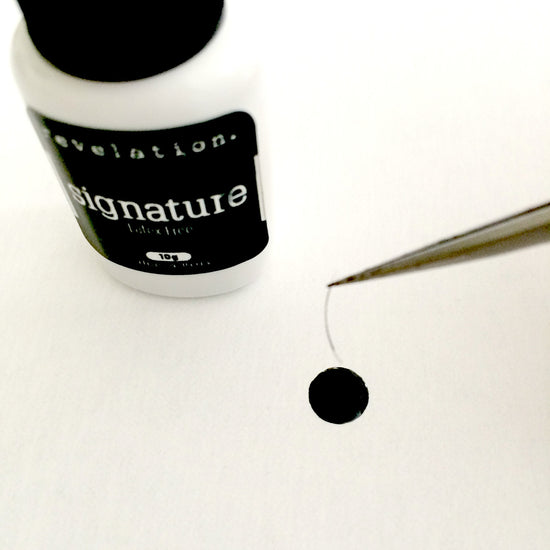 Image of Signature Latex Free Eyelash Extension Glue with tweezers coming into screen holing an individual eyelash extension being dipped in the glue.